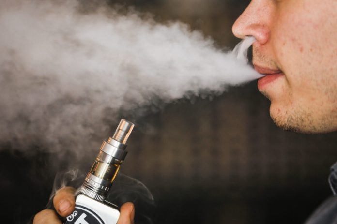 A man smokes an electronic cigarette vaporizer, also known as an e-cigarette, in Toronto